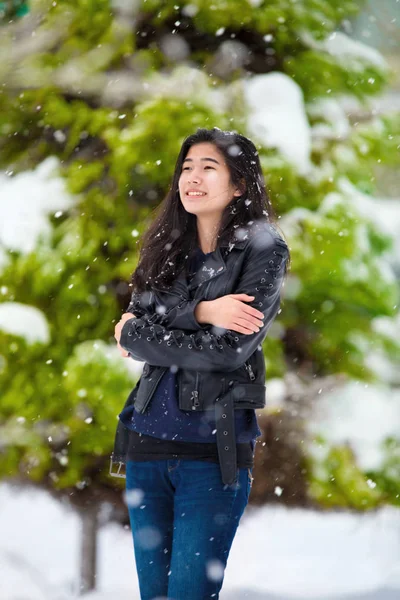 Tiener meisje staande buitenshuis in de winter sneeuwval rillen van c — Stockfoto