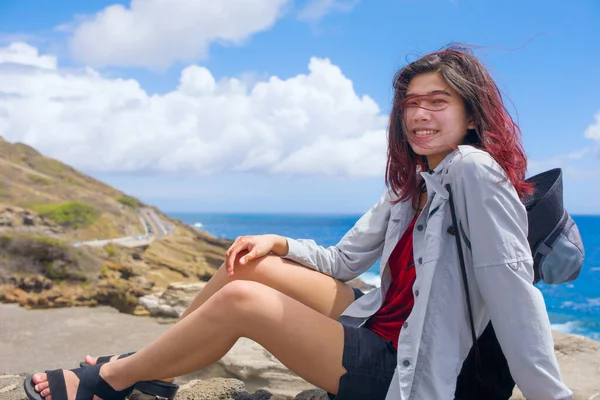 在夏威夷岛上 坐在摇摇晃晃的悬崖边 俯瞰热带蓝色太平洋的少女微笑着 — 图库照片