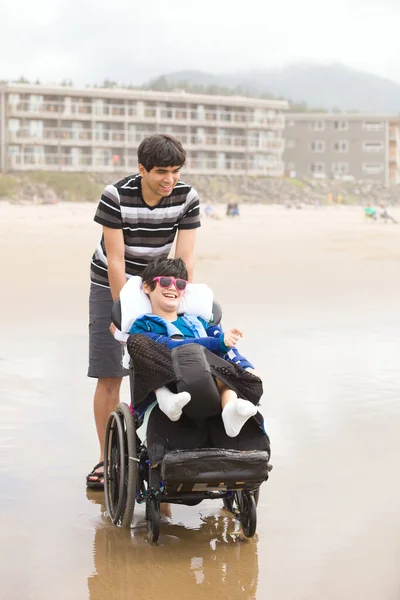 Young Biracial Asian Caucasian Man Pushing Disabled Little Brother Wheelchair — Stock Photo, Image