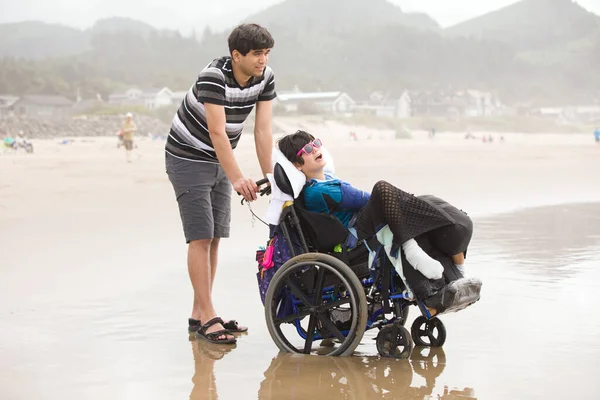 Young Biracial Asian Caucasian Man Pushing Disabled Little Brother Wheelchair — Stock Photo, Image