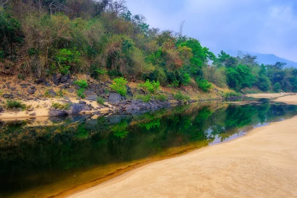 Paisaje de playa arenosa y pozo de agua al lado de acantilado rocoso y r — Foto de Stock