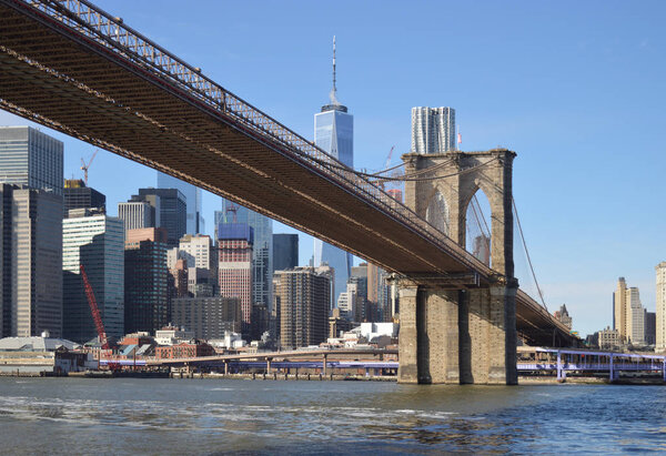 Lower Manhattan with Brooklyn Bridge at sunny day.