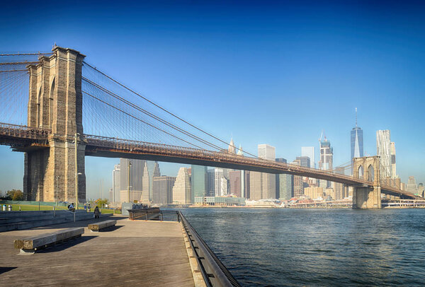 Manhattan skyline with Brooklyn Bridge at sunny day.