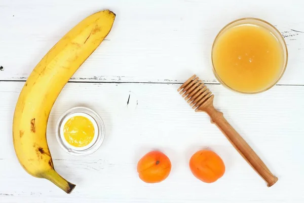Face mask fron banana, honey, apricot and bee glue. Ingredients for facial mask on the white board, top view
