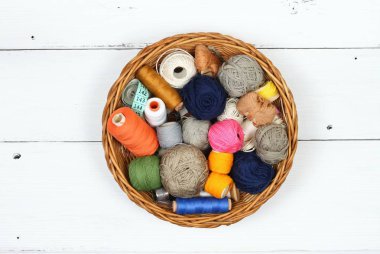 Beyaz ahşap tahta, üstten görünüm üzerinde sepetteki renkli dikiş ipliği