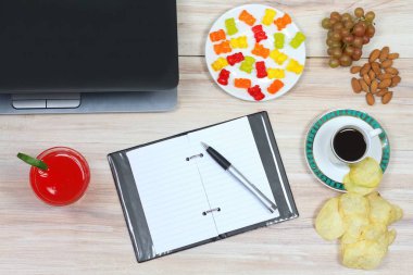 Tasarımcı kahvaltı ve boş not defteri. Fincan kahve, meyve suyu, gevrek patates cipsi, glasess durumda, defter ve Not defteri  