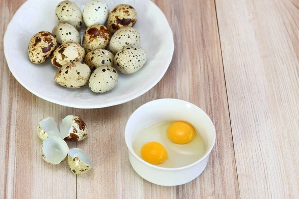 两只生的鹌鹑蛋在一个白色的碗里 鹌鹑在白盘子和 Partrige 壳上发现卵 — 图库照片