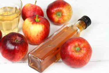 Elma sirkesi şişe ve cam. Fersh elma çevresinde beyaz ahşap tablo 