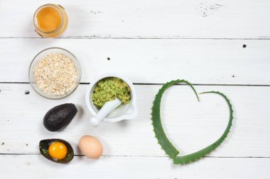 Yüz maskesi için malzemeler; avokado, aloe vera, yumurta, yulaf ezmesi, tatlım. Alternatif Tıp kavramı, ev yapımı yüz ya da saç maskesi 