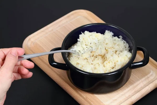 叉子上和锅里的酸菜 发酵或腌制卷心菜 在切菜板上 黑色背景 — 图库照片