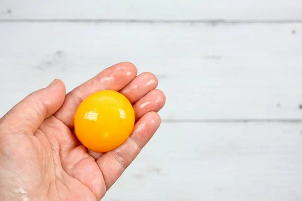 卵黄は手で区切られ 平らなレイアウト 女性の手で調理のための壊れた卵 白いテーブルの背景 — ストック写真