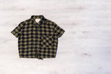 Damalı kadın gömlek hafif bir ahşap arka plan üzerinde yalan