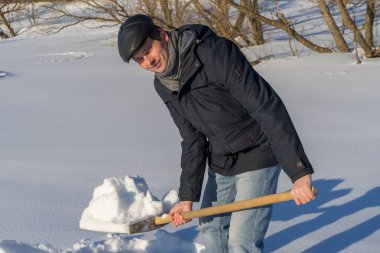 Yakışıklı orta yaşlı beyaz adam kar ev arsa üzerinde temizler