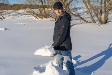 Yakışıklı orta yaşlı beyaz adam kar ev arsa üzerinde temizler