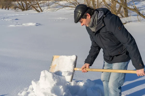 Yakışıklı orta yaşlı beyaz adam kar ev arsa üzerinde temizler