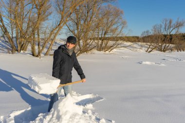 Yakışıklı orta yaşlı beyaz adam kar ev arsa üzerinde temizler