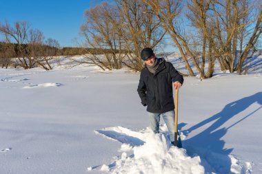 Yakışıklı orta yaşlı beyaz adam kar ev arsa üzerinde temizler