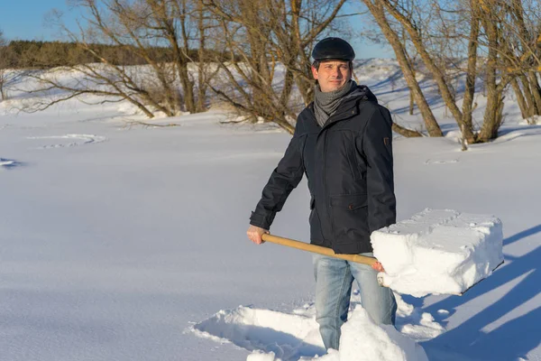 Yakışıklı orta yaşlı beyaz adam kar ev arsa üzerinde temizler