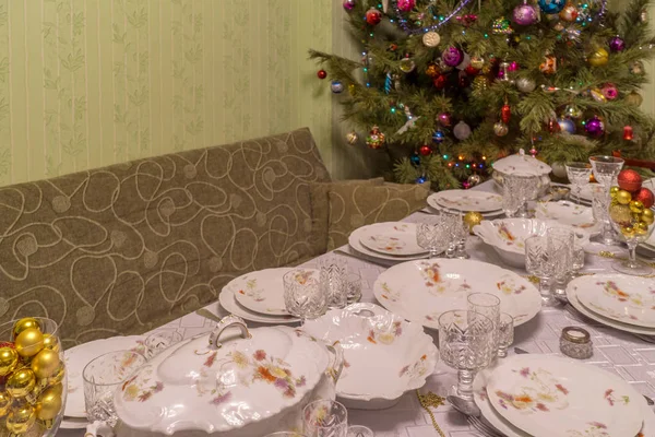 Сервированный стол с праздничной посудой рядом с красивым украшенным Chr — стоковое фото