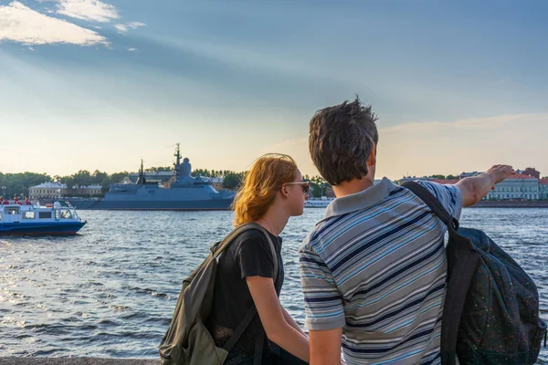 Middle-aged dark-haired man and young redhead lady on Neva river