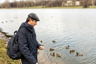 Yakışıklı esmer orta yaşlı erkek ceket, kap ve sırt çantası