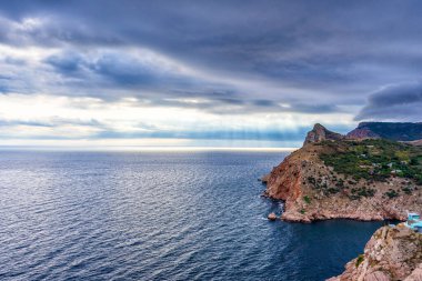Dağ bölgesinde deniz kıyıları olan güzel panoramik bir manzara. Sonbahar bulutlu bir günde gökyüzü, su ve sahil manzaralı bir deniz manzarası. Karadeniz, Sivastopol çevresi, Kırım, Ukrayna.