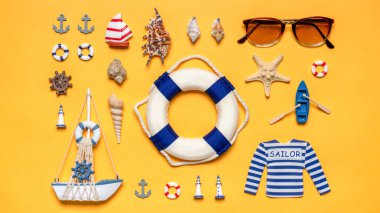Çeşitli dekoratif deniz eşyaları, yelkenli, can simidi ve parlak sarı arka planda güneş gözlüğü. Aramıza hoş geldin mesajı. Deniz yolculuğu, okyanus konseptinde yaz tatili. Düz yatış, üst görünüm.