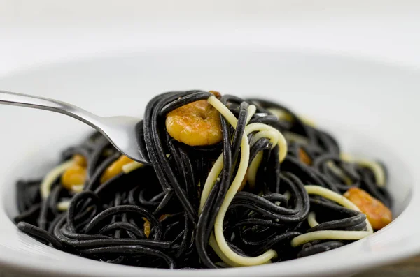 イタリアンブラックスパゲッティ アラー ベネチアーナ 焼きエビとドライトマト オリーブオイル ニンニク いくつかの白いスパゲッティを使用して効果を発揮 — ストック写真