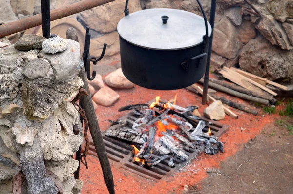 Brûler du bois sur une grille avec une casserole — Photo