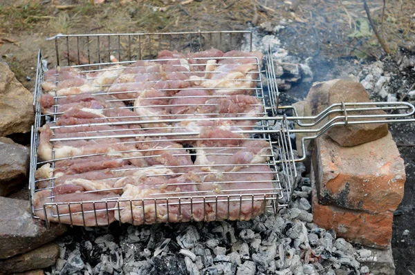 Viande sur un gril couché sur des pierres — Photo