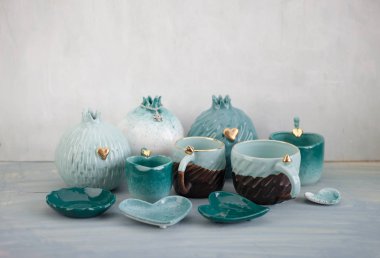Gri masada turkuaz çömlek bir sürü.