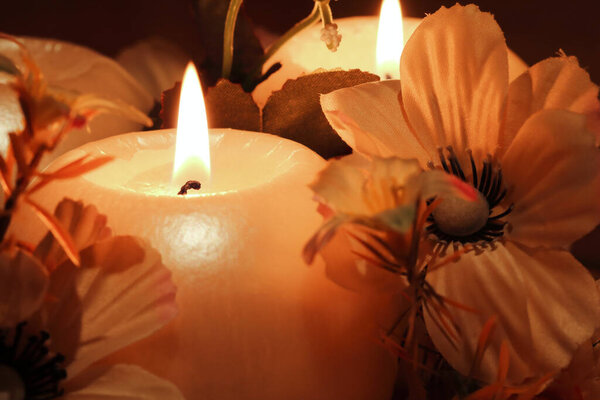 Burning candles with decoration on dark background.