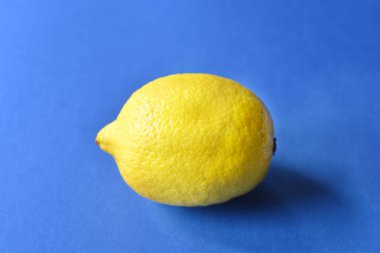 Mavi Kağıt arka plan üzerinde sarı taze limon