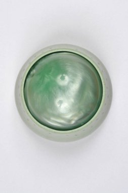 Beyaz stüdyo arka planında parıldayan küresi olan yeşil bir el masajcısının yukarıdan görünüşü