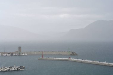 Yağmurlu ve bulutlu bir günde Krk adasındaki Baska limanının manzarası