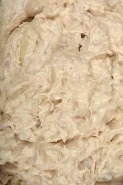 Dokulu yakın plan, yukarıdan aşağıya doğru yayılmış kremalı ton balığı ve krem peyniri gösteriyor.