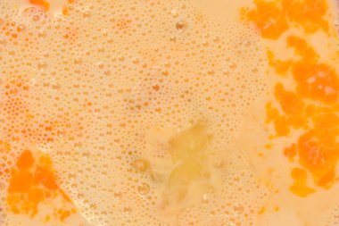 Görünür yumurta sarısı ve baloncuklu çırpılmış yumurtaların detaylı makro görüntüsü.