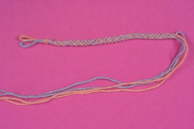 Bitmemiş, el yapımı pembe ve mor düğümlü pembe bir arkadaşlık bileziği.