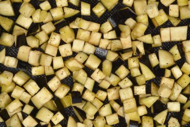 Zeytinyağı, tuz ve biberli taze doğranmış patlıcanların makro, yakın çekimli, tepeden tırnağa fırın kabında kızartılmaya hazır.