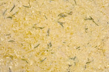 Fırınlanmaya hazır çiğ patates Scarpaccia manzarası, görünür patates iplikleri ve kremalı bir yüzeyde taze biberiye filizleri.