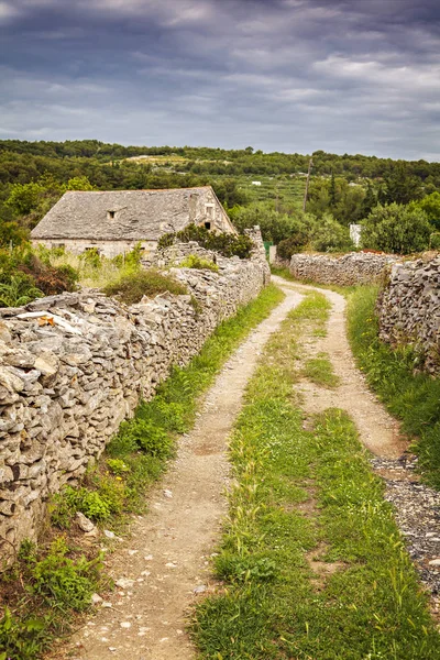 Gravel path to old stone house. Island of Brac, Croatia.