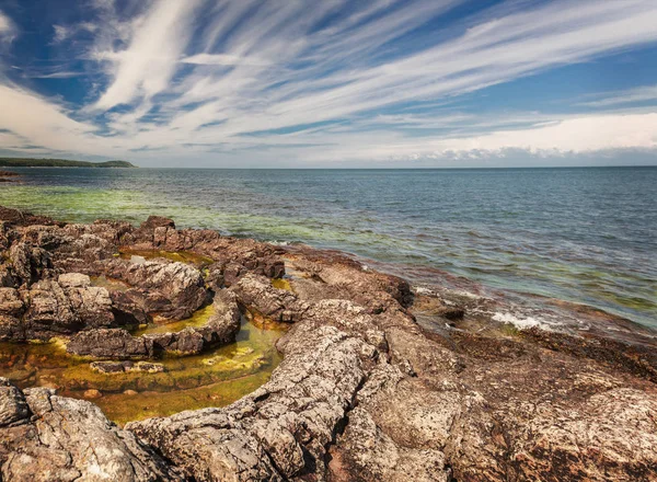 Circular geological feature on rocky beach. Vik, Sweden.
