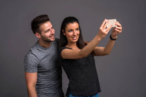 Belo Jovem Casal Tirando Uma Selfie Com Smartphone Estúdio — Fotografia de Stock