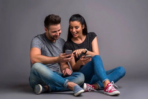 Beautiful Young Couple Sitting Ground Showing Smartphones Each Other — Stock Photo, Image