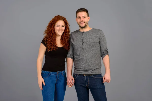 A beautiful young couple standing and laughing in good mood