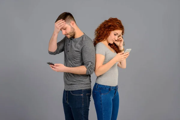 Belo Jovem Casal Costas Para Trás Segurando Seus Smartphones Sentindo — Fotografia de Stock