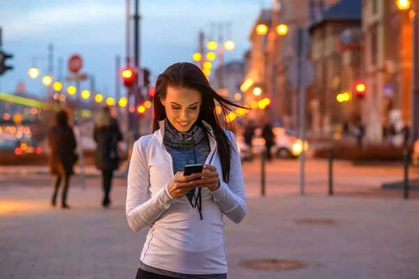 Vacker Ung Kvinna Klädd Sportkläder Och Står Med Sin Telefon — Stockfoto