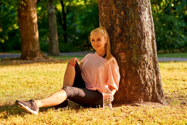 Schöne Junge Sportliche Frau Sitzt Einem Baum Einem Park Sonnenuntergang — Stockfoto