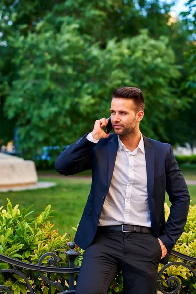 Bel Giovane Uomo Affari Appoggiato Alla Recinzione Parco Mentre Parla — Foto Stock