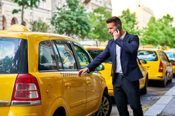 Przystojny Młody Biznesmen Chodzenie Taksówki Ulicy Podczas Rozmowy Telefon — Zdjęcie stockowe
